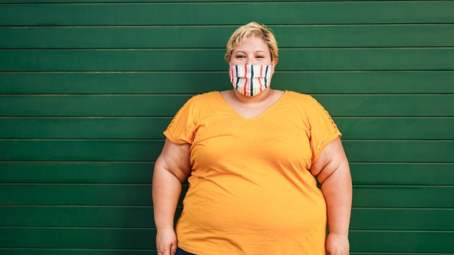 Happy plus size woman wearing a face protective mask during coronavirus outbreak